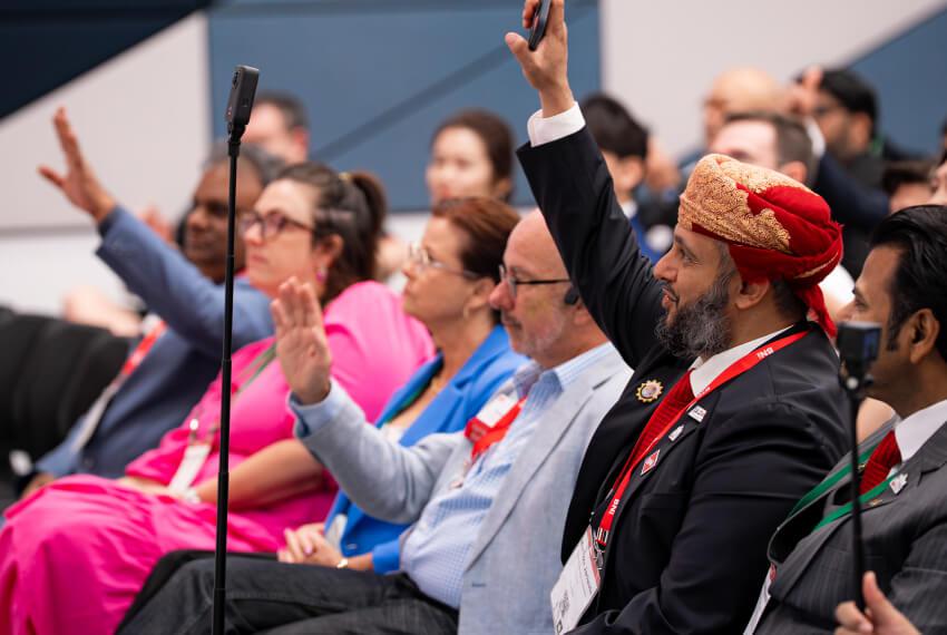 BNI event attendees raising hands during an interactive networking conference session